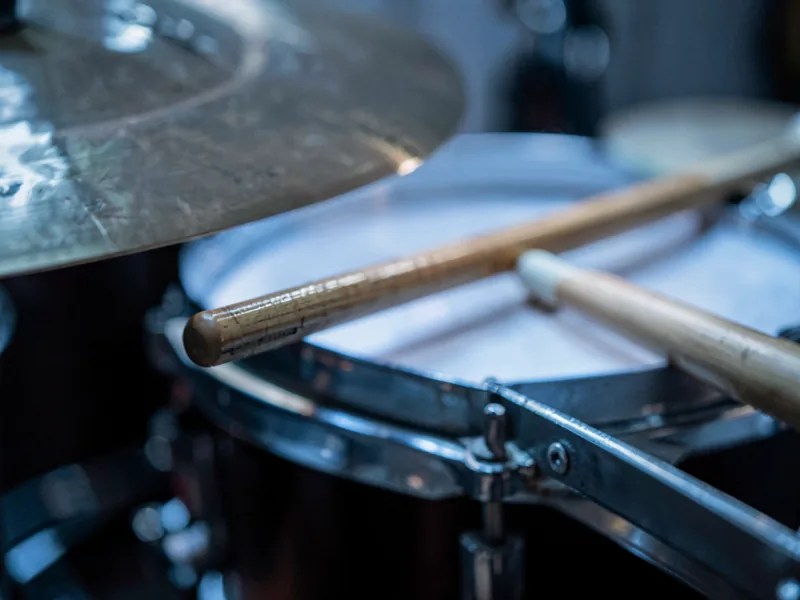 Macro of a cymbal and drum sticks resting on the snare rim